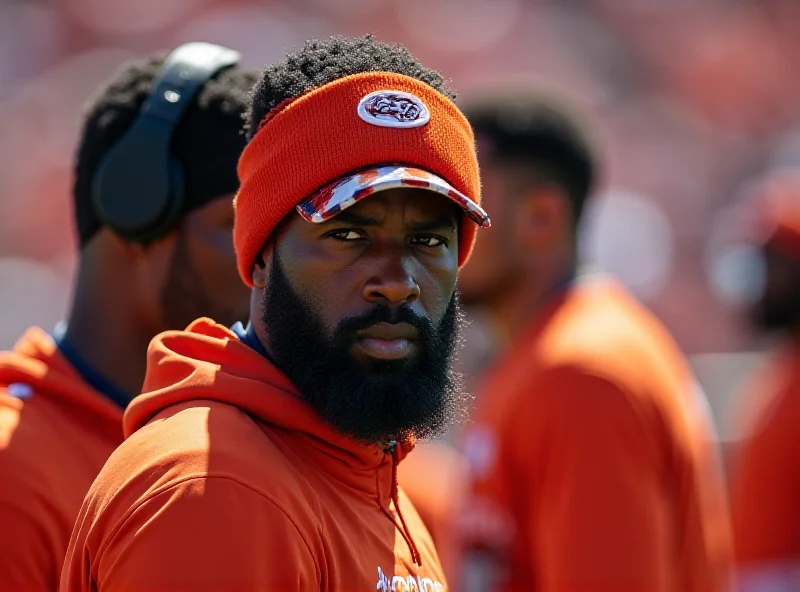 Michael Wilhoite on the sidelines during a Denver Broncos game, looking serious and focused.