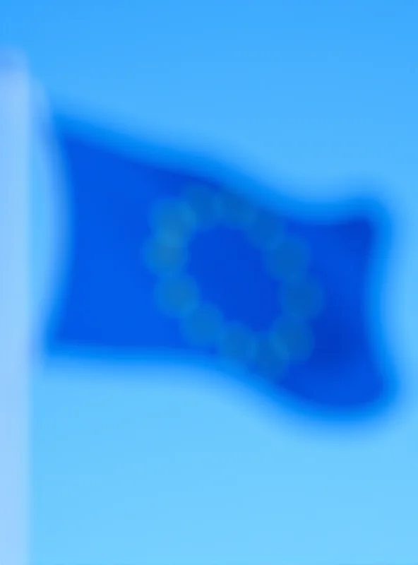 European Union flag waving in the wind against a blue sky