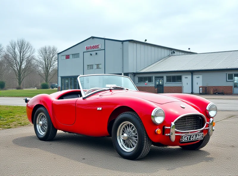 Classic AC Cobra sports car parked in front of the former Saab factory.