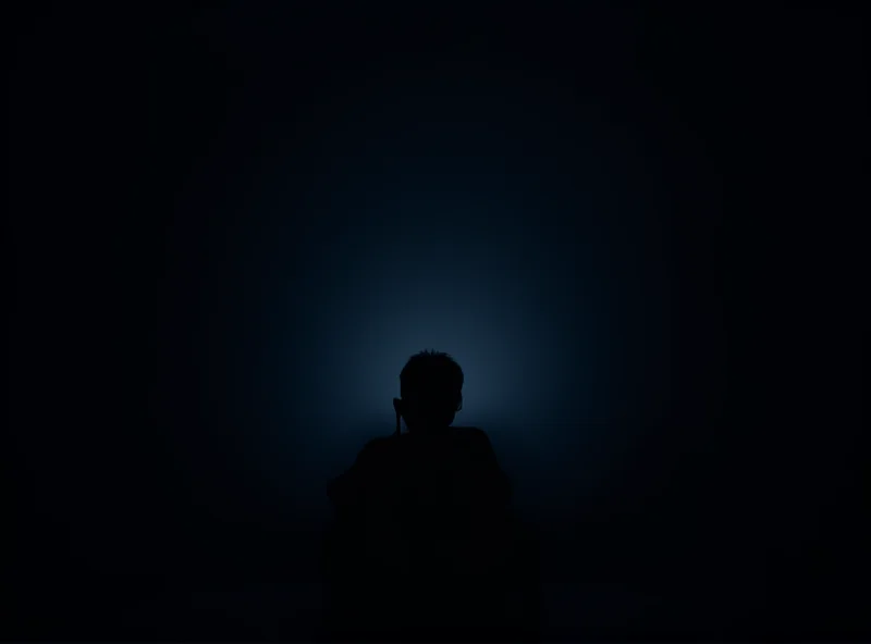 A child silhouetted against a bright screen, looking thoughtful