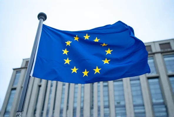 Image of the European Union flag waving in front of the Berlaymont building in Brussels