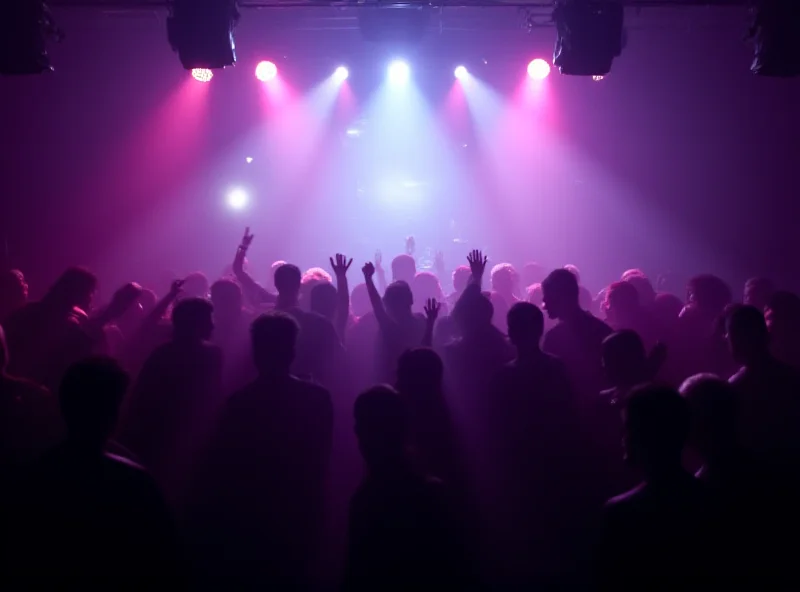 A large crowd of people dancing at a nightclub, with strobe lights flashing and loud music playing