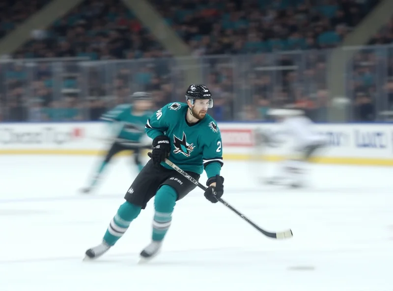 Jake Walman skating on ice during a hockey game, wearing a San Jose Sharks jersey.
