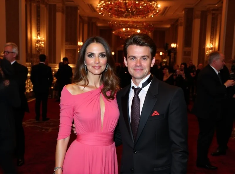 Elizabeth Hurley and her son Damian pose for photos at Elton John's Oscars viewing party. Elizabeth is wearing a pink gown and Damian is wearing a stylish suit.