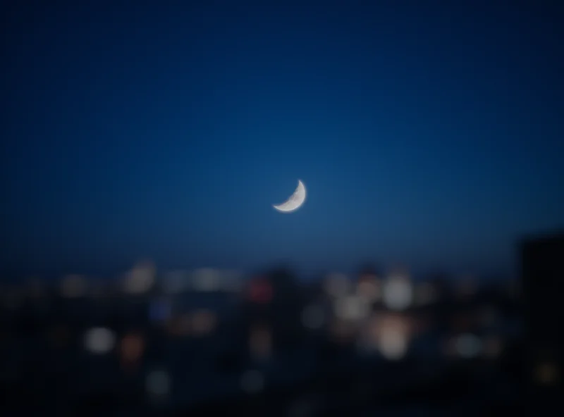 A crescent moon over a cityscape during Ramadan.