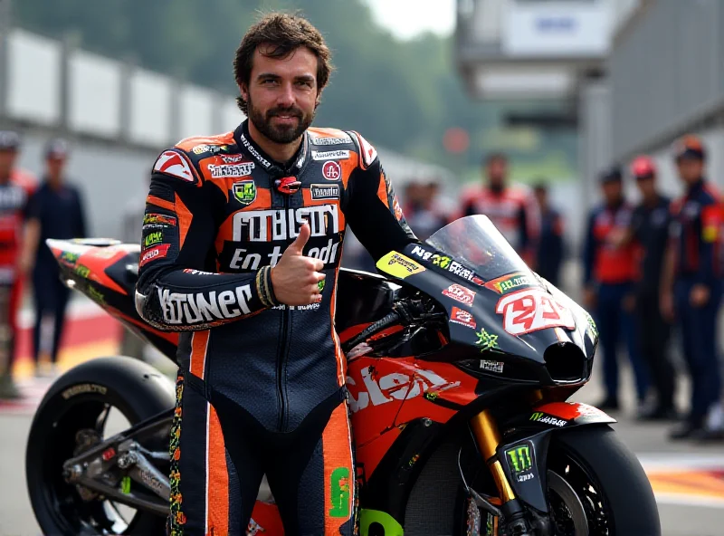 Andrea Iannone in his Superbike racing gear, giving a thumbs up with his motorcycle in the background.