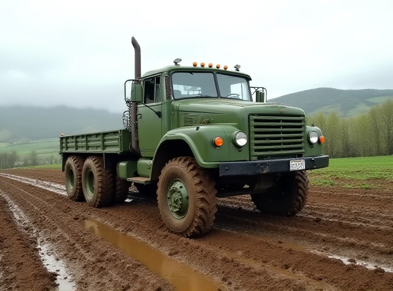 A Tatra T815 truck driving through a muddy field, showcasing its off-road capabilities.