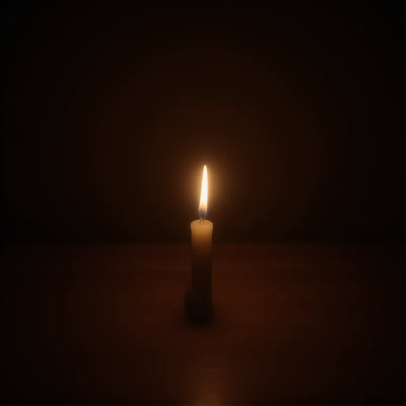 A candle burning in remembrance of the victims of the Bradford house fire, symbolizing grief and solidarity within the community.