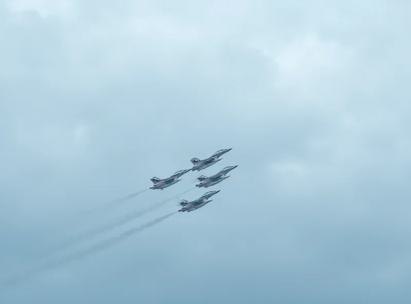 Military fighter jets flying in formation over a cloudy sky.